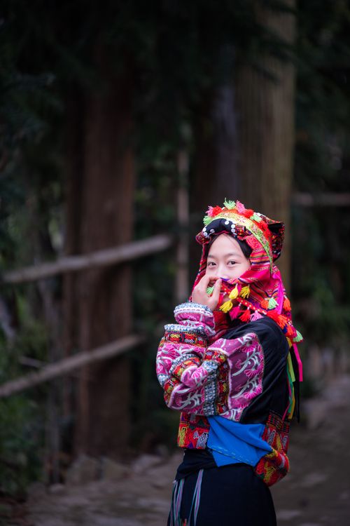 Free Person in colorful traditional dress stands outdoors, showcasing cultural heritage. Stock Photo