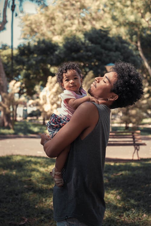 Free Man Carrying Baby in his Arms Stock Photo