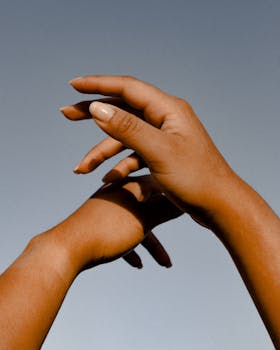 在晴朗天空背景下，优雅的手成为艺术照片的焦点