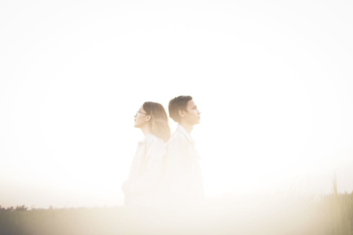 Man And Woman Standing Back To Back
