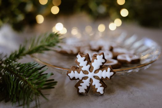 Close-up of a snowflake-shaped cookie with holiday decorations.