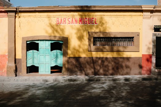 Yellow Mexican bar facade with turquoise doors in San Miguel de Allende.