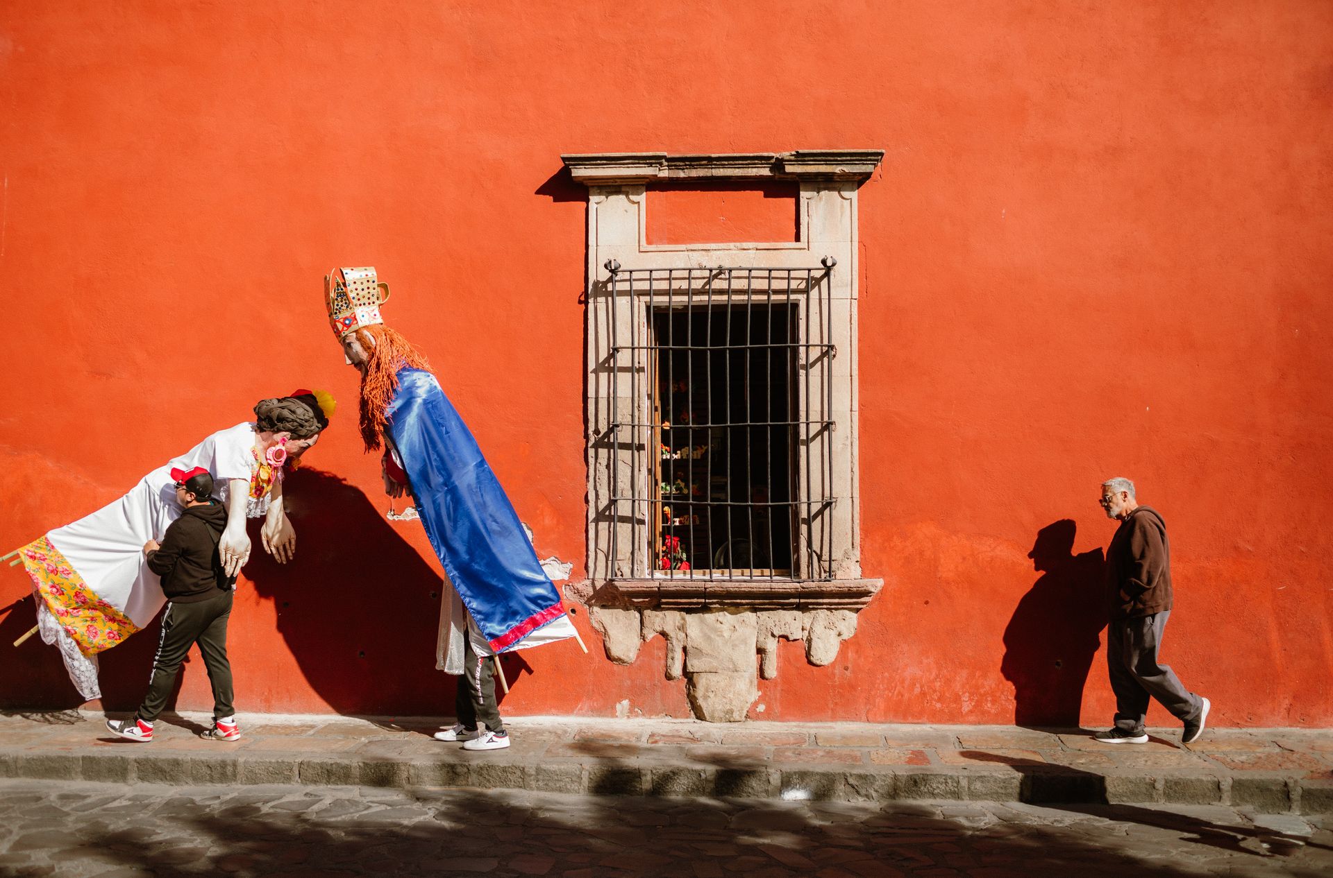 Vibrant street scene with colorful costumes and pedestrians in San Miguel de Allende, Mexico.