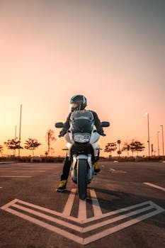 Biker on a motorcycle enjoying an open road at sunset, embodying freedom and adventure.