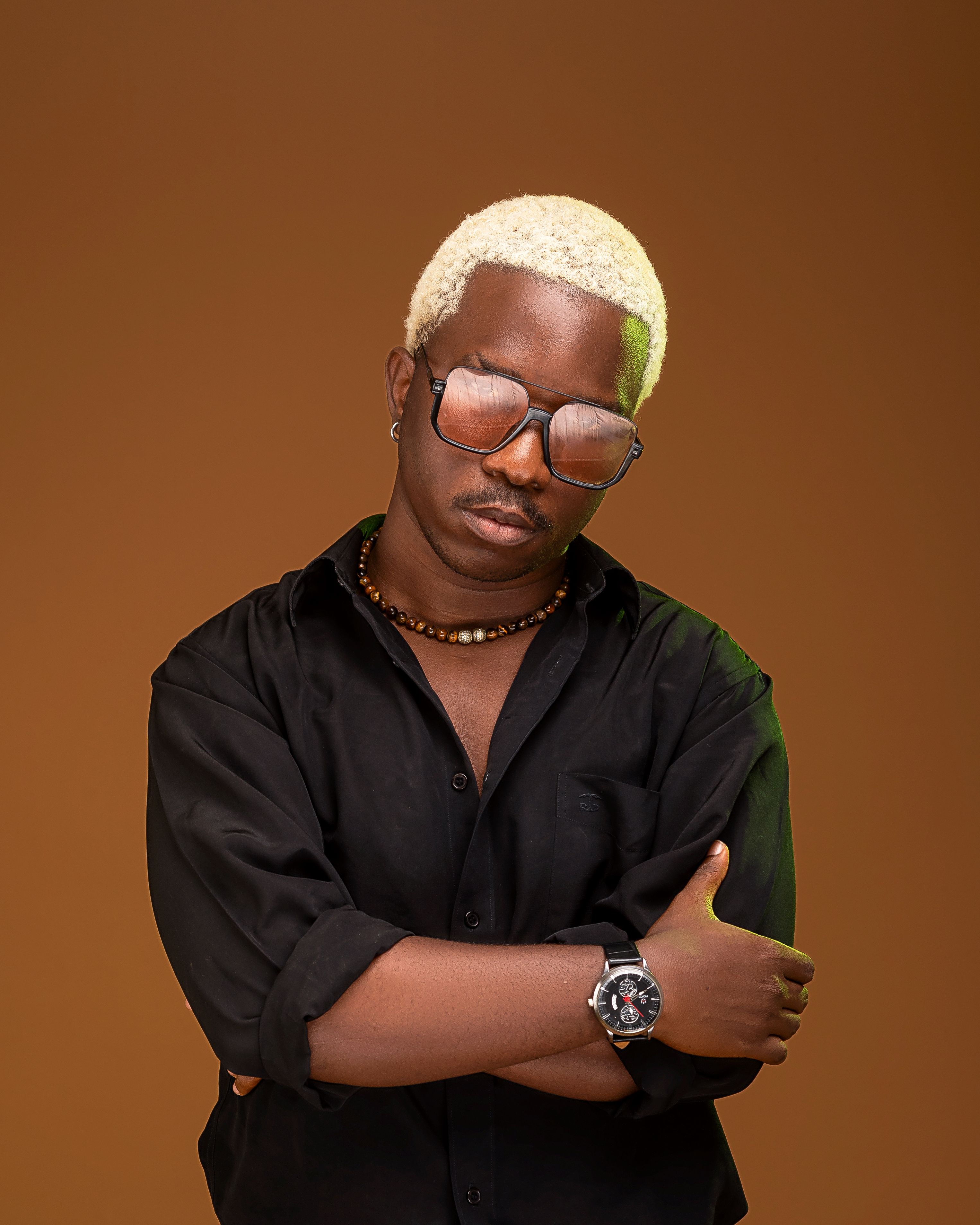 Casual portrait of stylish adult wearing sunglasses and black shirt with confident pose.