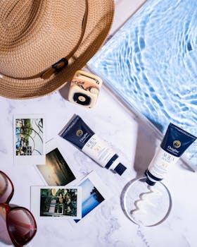 Flat lay of sunblock, photos, and summer accessories by the poolside, highlighting relaxation.