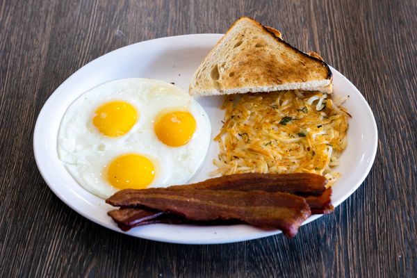 Diner breakfast of sunny-side-up eggs, bacon, hash browns and toast — photo by Snappr on Pexels