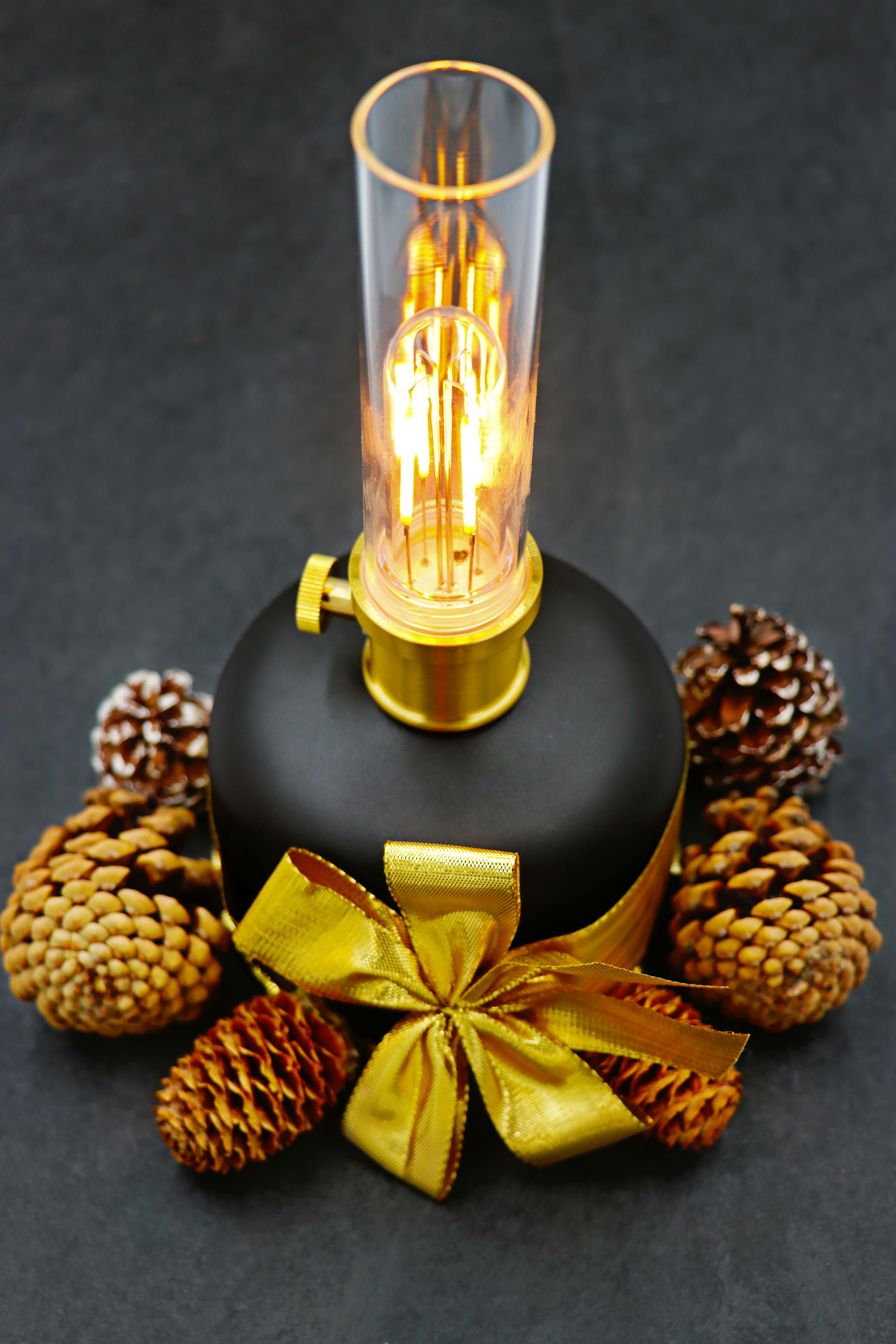 elegant festive lamp with pine cones and gold ribbon