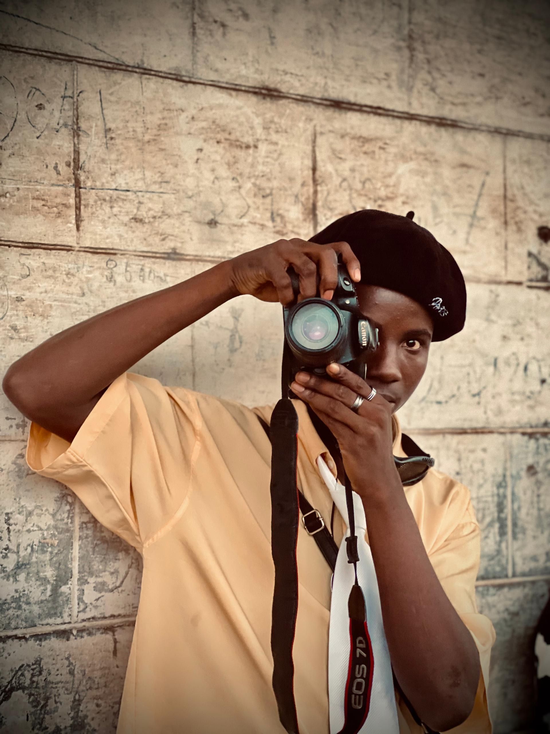 A photographer with a vintage camera taking pictures in an urban setting.