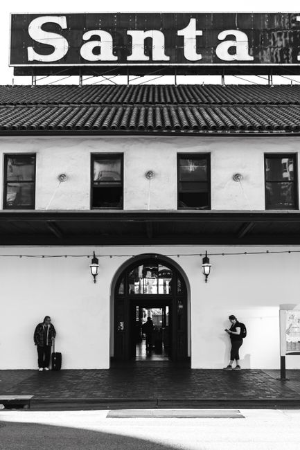 Monochrome image of two people at Santa station entrance, capturing an urban vibe.