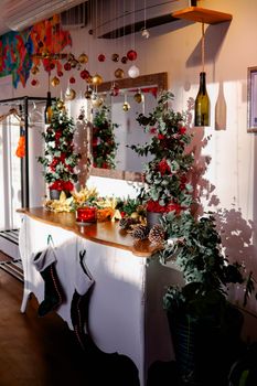 A cozy indoor setup with holiday garland, ornaments, and stockings hung on a decorated dresser.