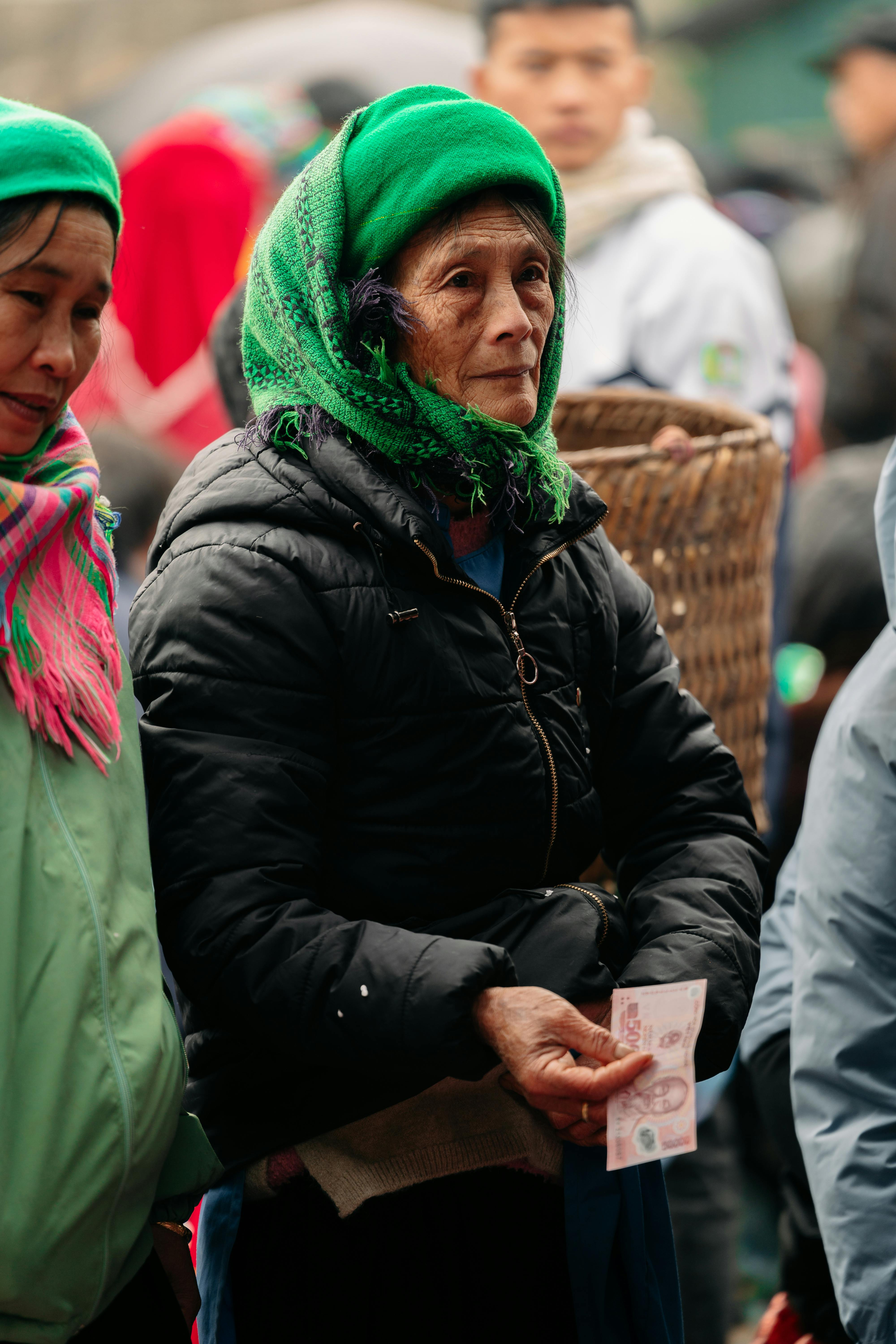 Women wearing traditional attire at a market in Hà Giang, Vietnam, with vibrant colors and cultural diversity.
