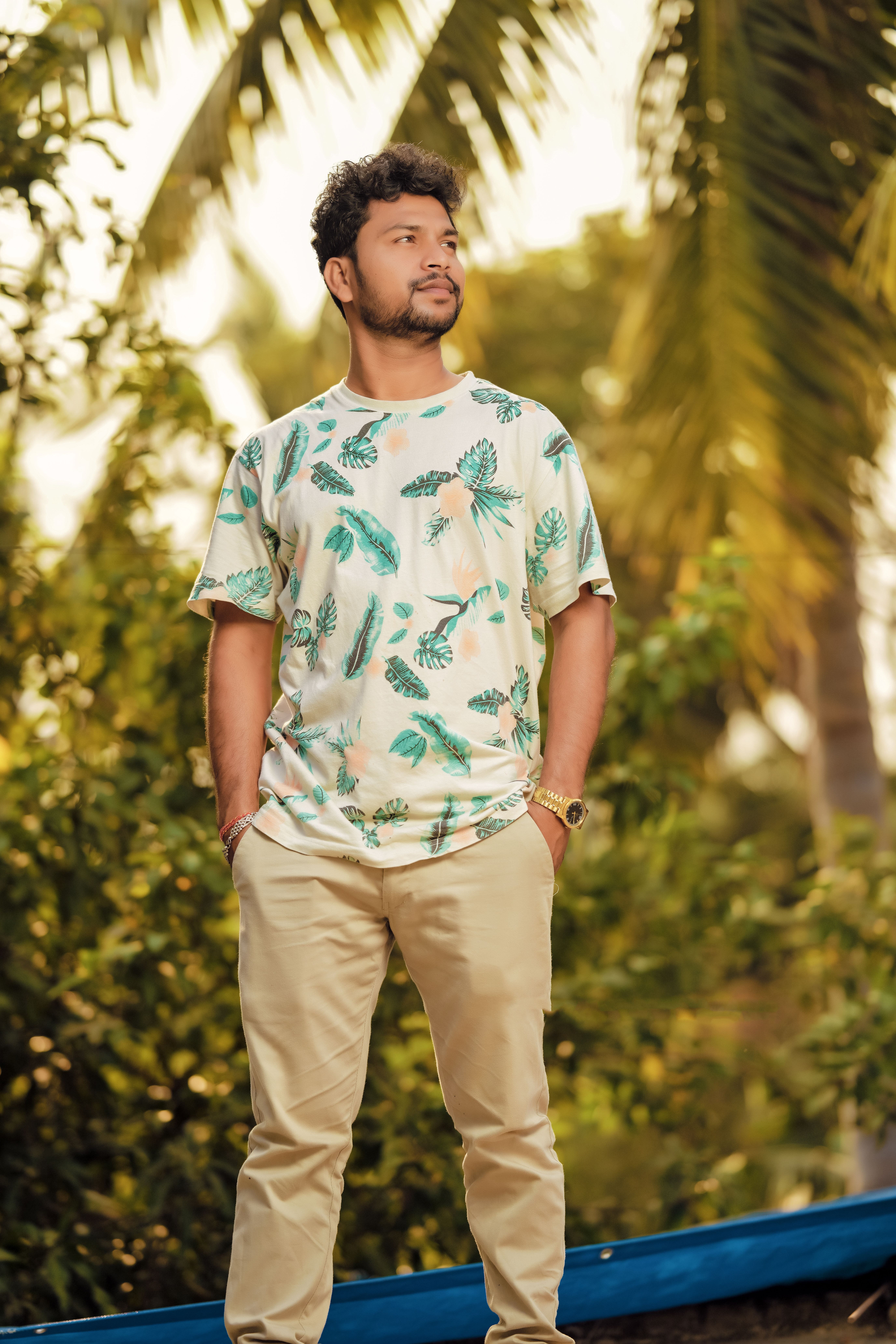 Portrait of a young man in casual summer attire with a tropical background.