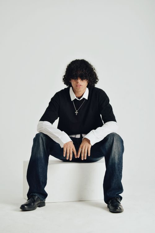 Free Portrait of a young man sitting confidently in a modern studio setting in Cairo, Egypt. Stock Photo