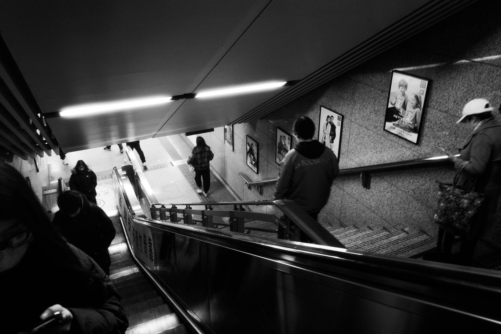 Black and white view of an escalator in a transit station