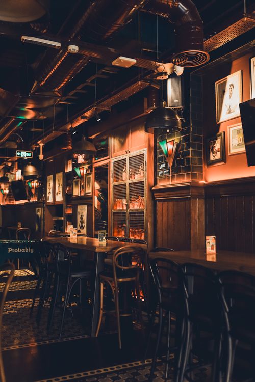 Free A charming vintage pub interior with dim lighting, creating a cozy atmosphere. Stock Photo
