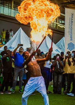 A fire performer thrills a lively crowd at an outdoor event in Lagos, Nigeria.