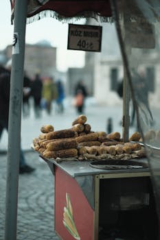 A street vendor selling grilled corn at an outdoor market with people in the background.