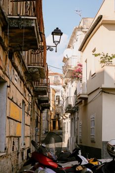 A picturesque alley in Italy with motorbikes, balconies, and vibrant flowers, capturing the essence of Italian architecture.