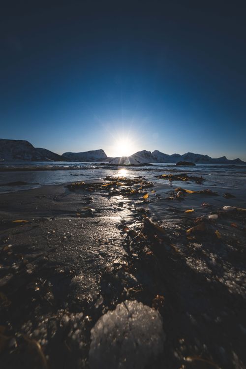 Free Captivating sunrise over a snow-covered mountain landscape with icy foreground. Stock Photo