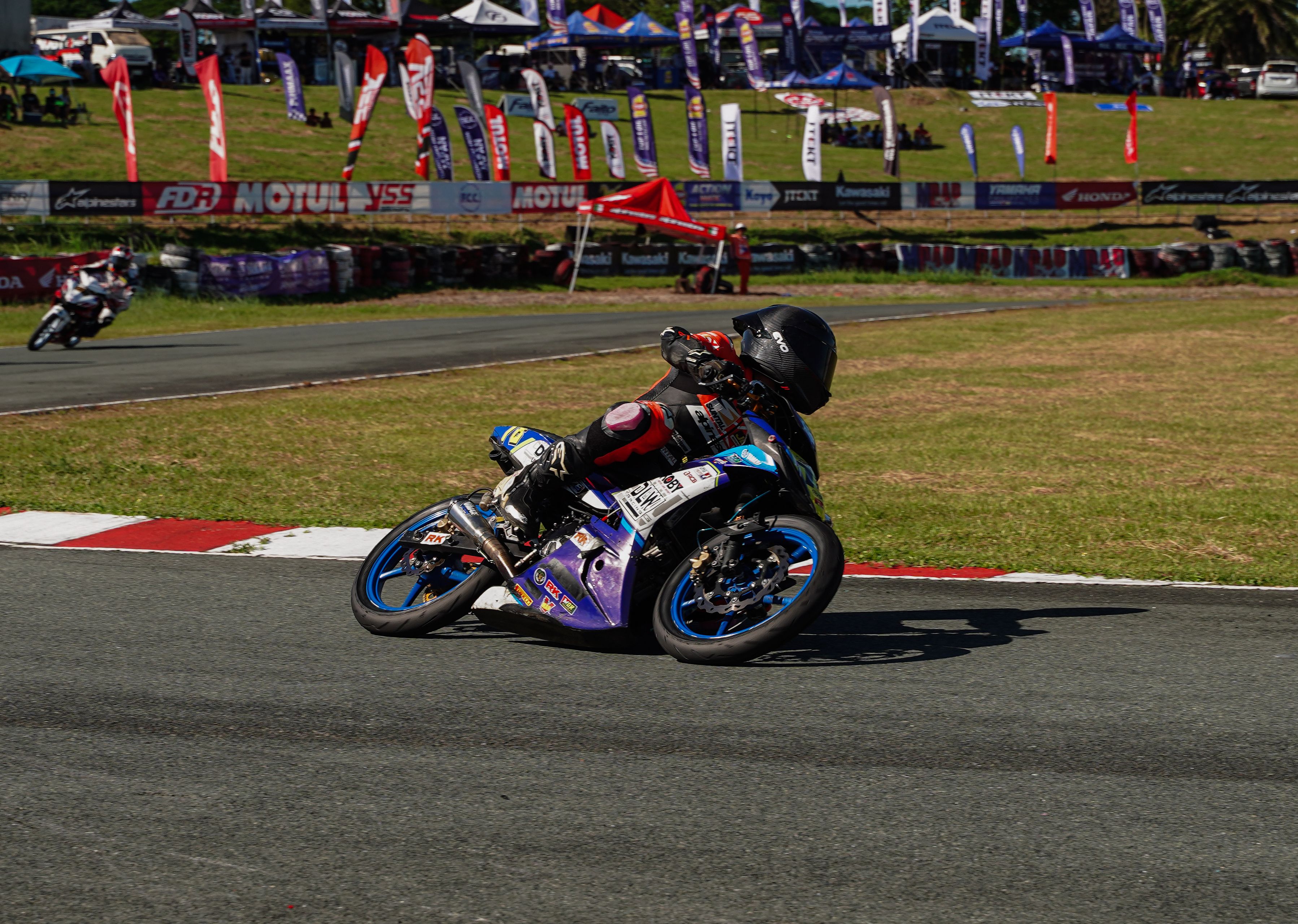 Thrilling motorcycle race under clear skies in Tarlac City, Philippines.