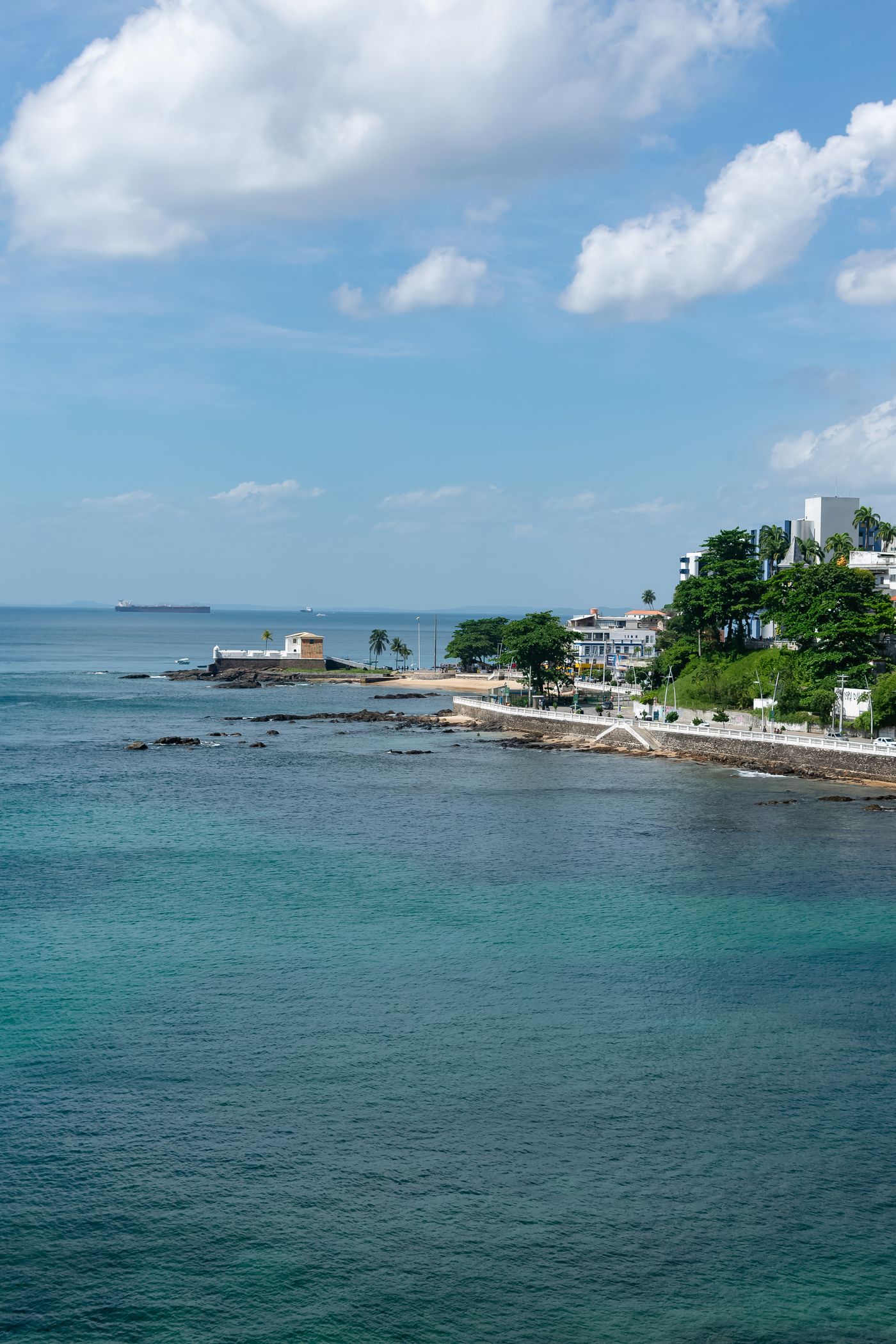 Vista da costa de Salvador com o mar azul-turquesa e um navio ao horizonte