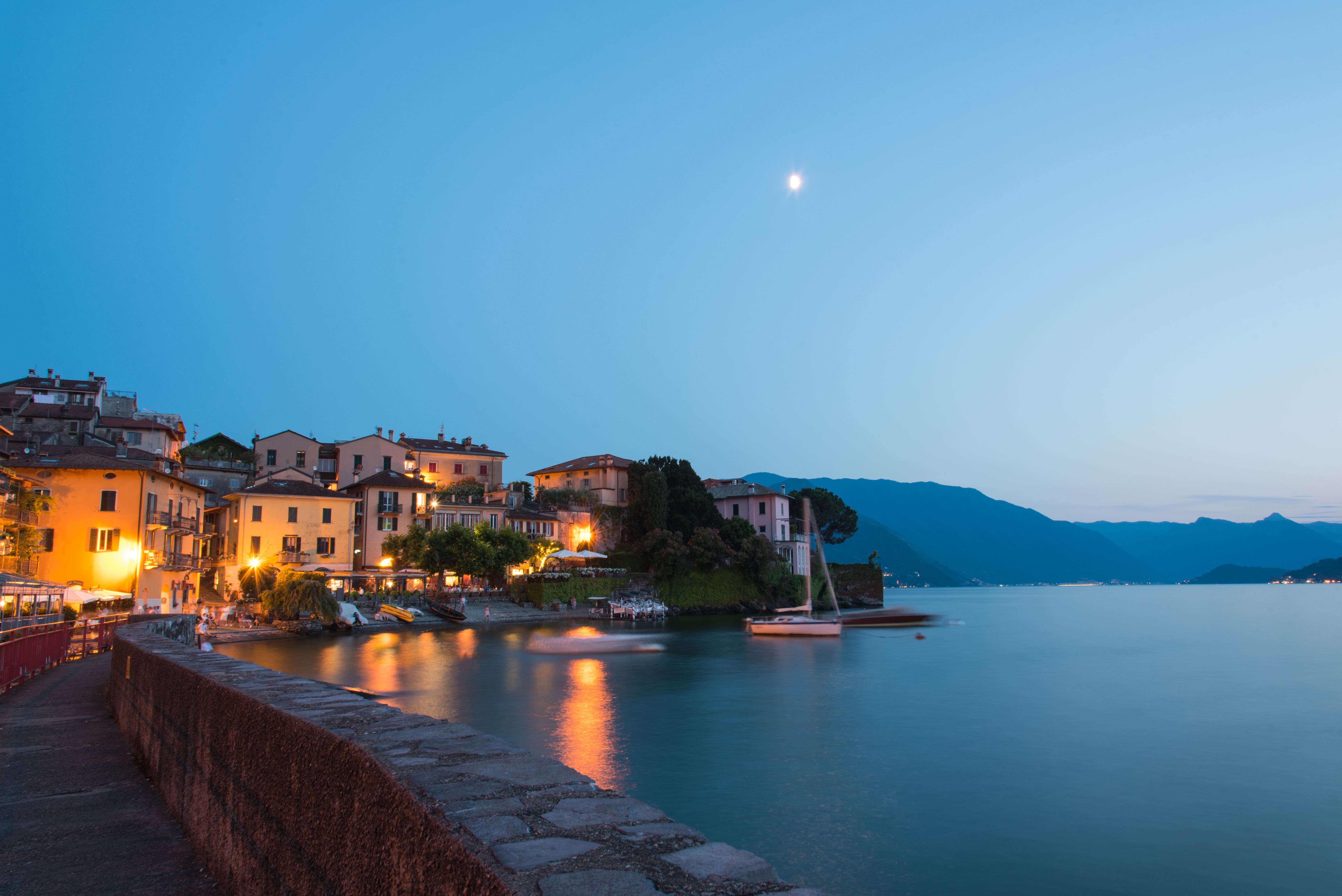 Captivating twilight view of colorful buildings along Lake Como in Lombardy, Italy with mountain backdrop. Captivating twilight view of colorful buildings along Lake Como in Lombardy, Italy with mountain backdrop.