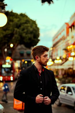 Man in a dark suit on a lit city street, photo by Cesar O Neill on Pexels