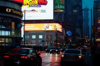 Dynamic city street scene in Toronto with vibrant billboards and bustling traffic.