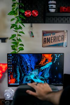 A cozy workspace features a vibrant abstract screen and greenery.