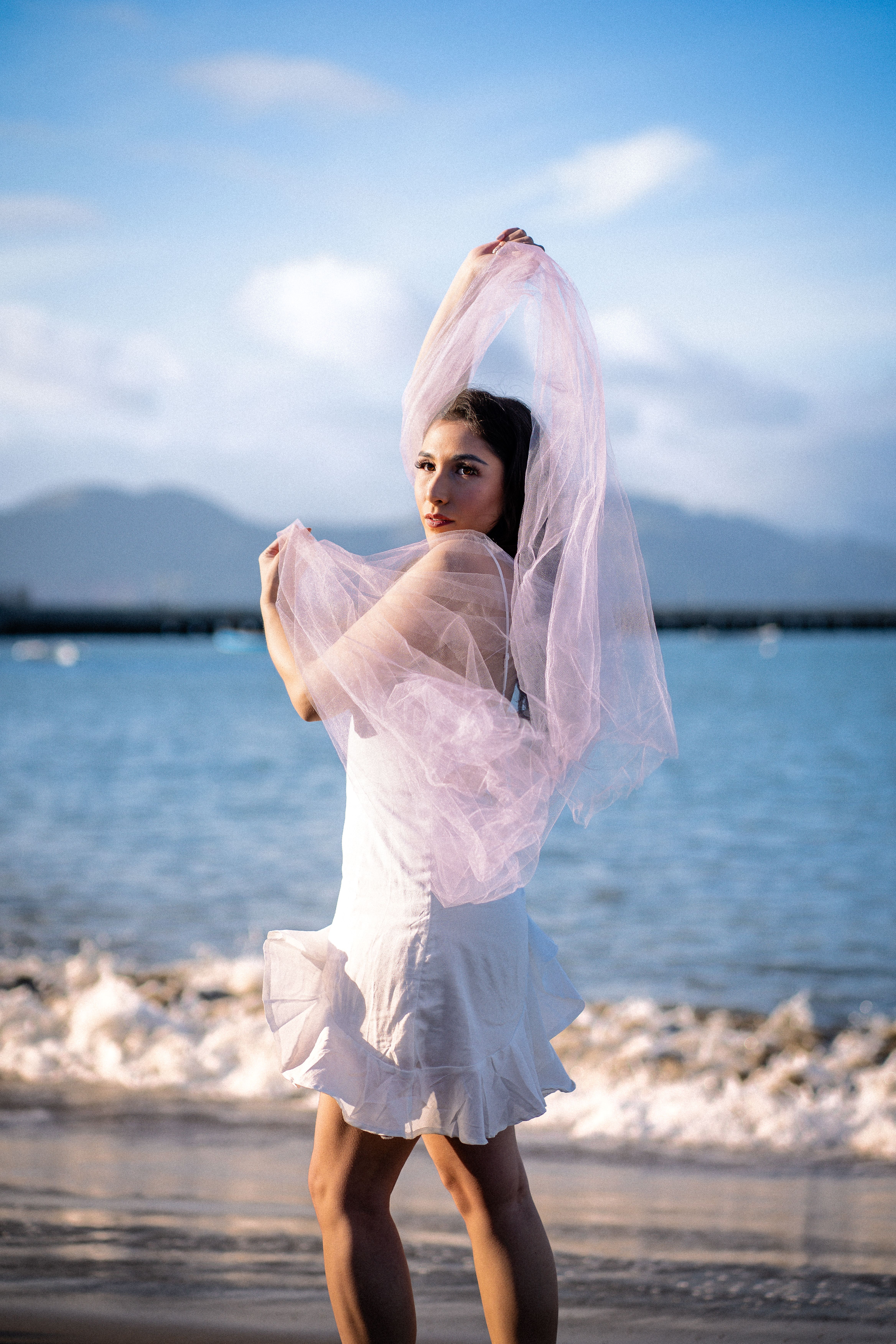 Elegant Woman Posing with Veil by the Seaside · Free Stock Photo