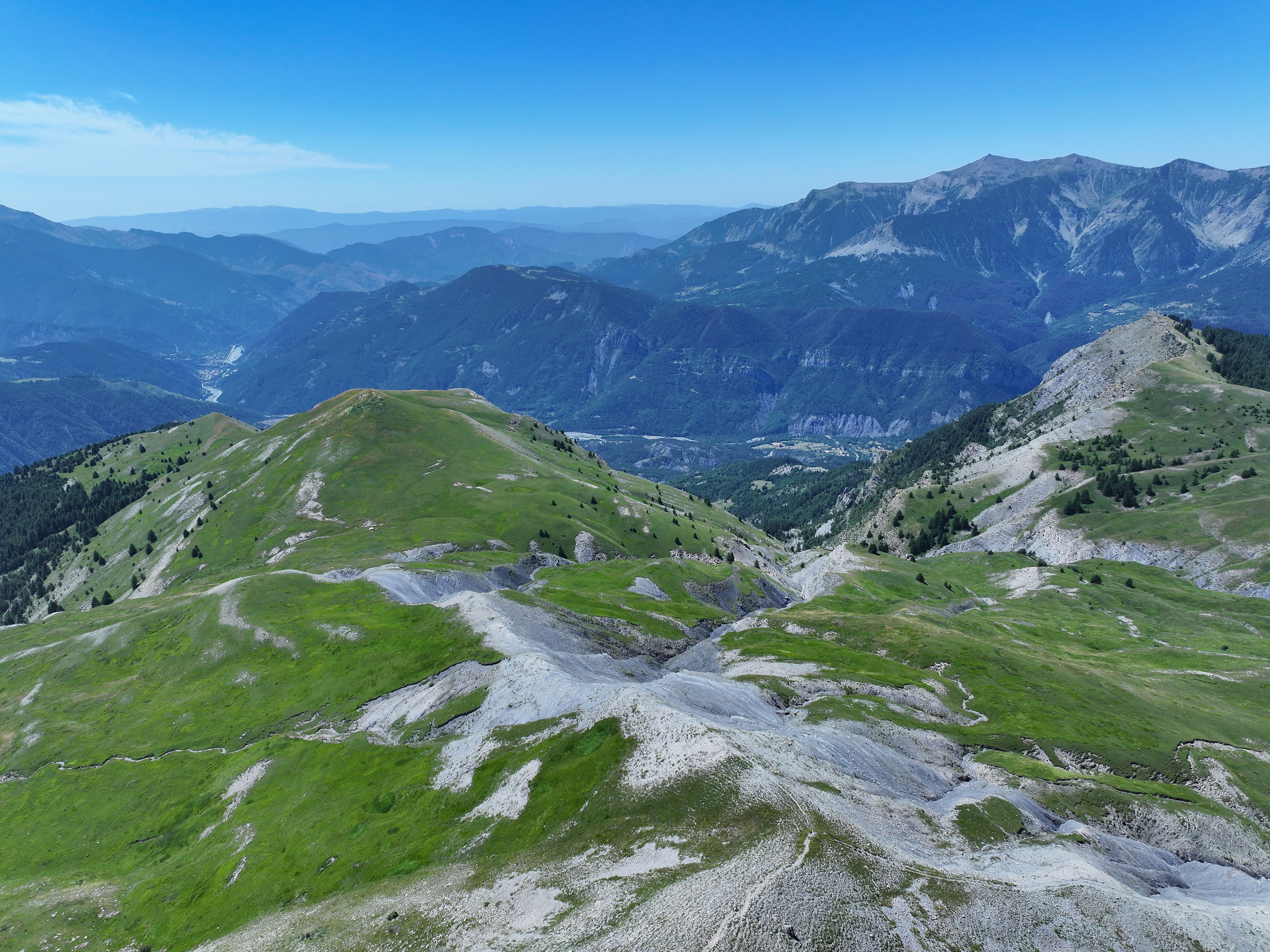 A breathtaking view of rugged mountains and lush green valleys in the French Alps.