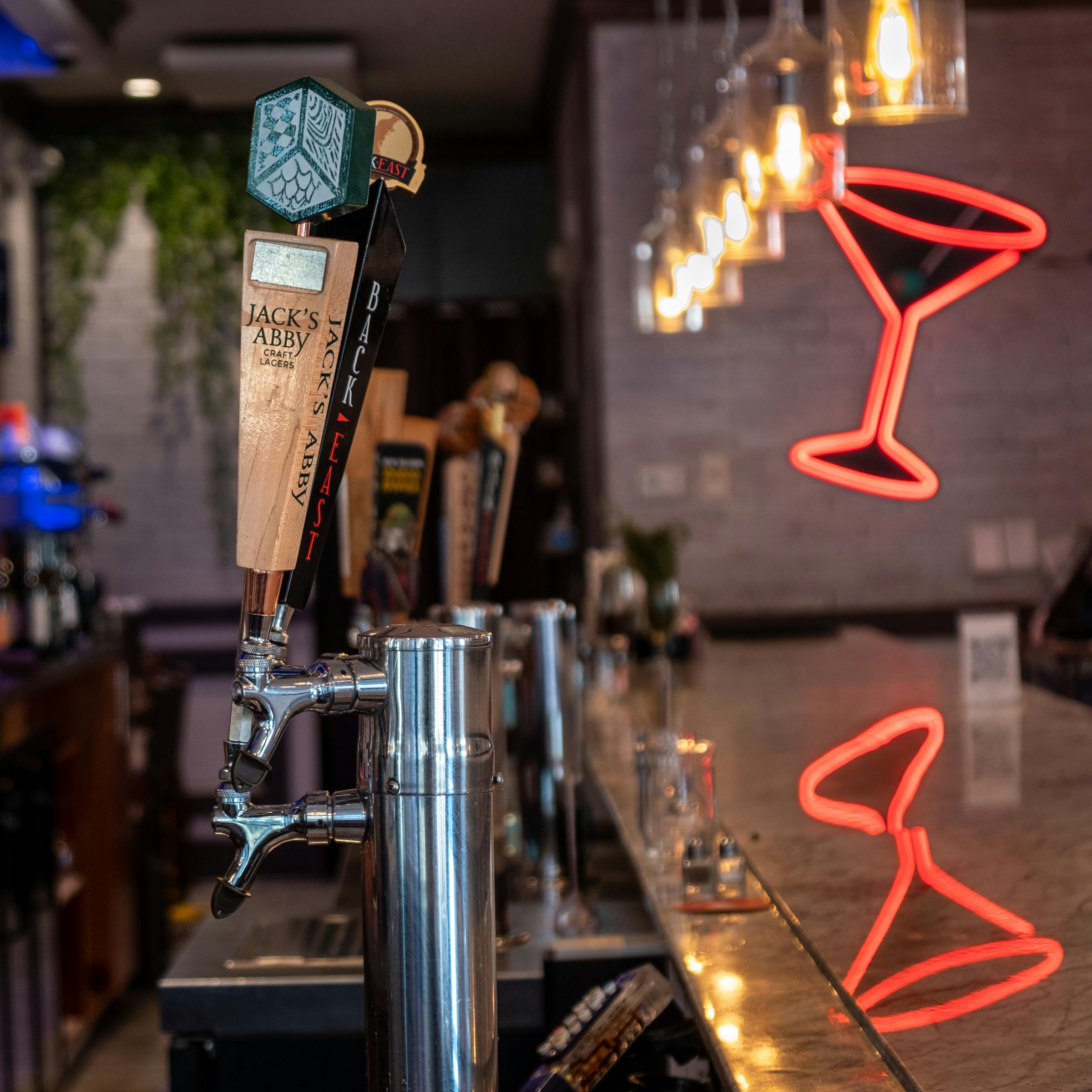 Wine and beer glasses on a dark moody bar counter
