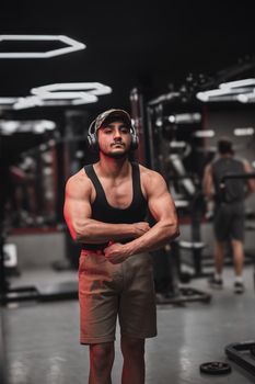 Man with strong build posing confidently in a gym. Fitness, strength, and workout concepts.