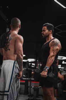 Two men focused on strength training, lifting weights in a modern gym setting.