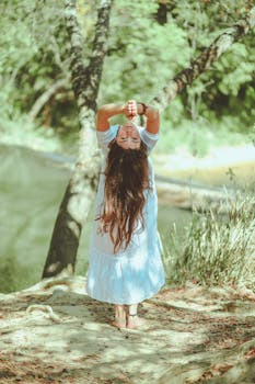 一个女人在宁静的湖边做瑜伽，享受着夏日的宁静