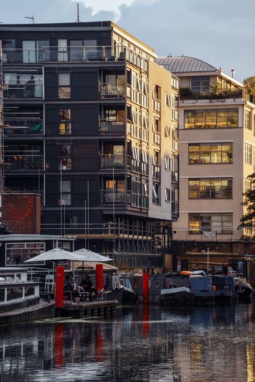 Free Contemporary buildings reflecting on a calm city canal in London, showcasing urban living. Stock Photo