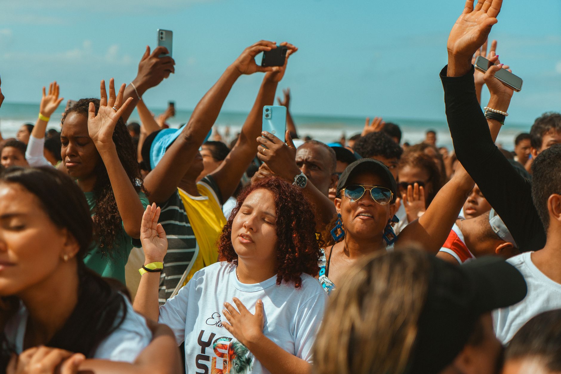 A vibrant group of people celebrating at a sunny beach, capturing joy and unity.