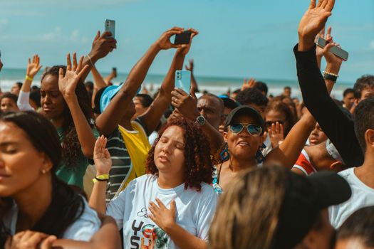 A vibrant group of people celebrating at a sunny beach, capturing joy and unity.