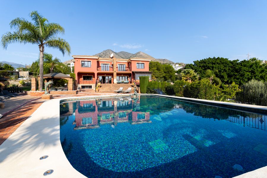 Maison terracotta reflétée dans la piscine
