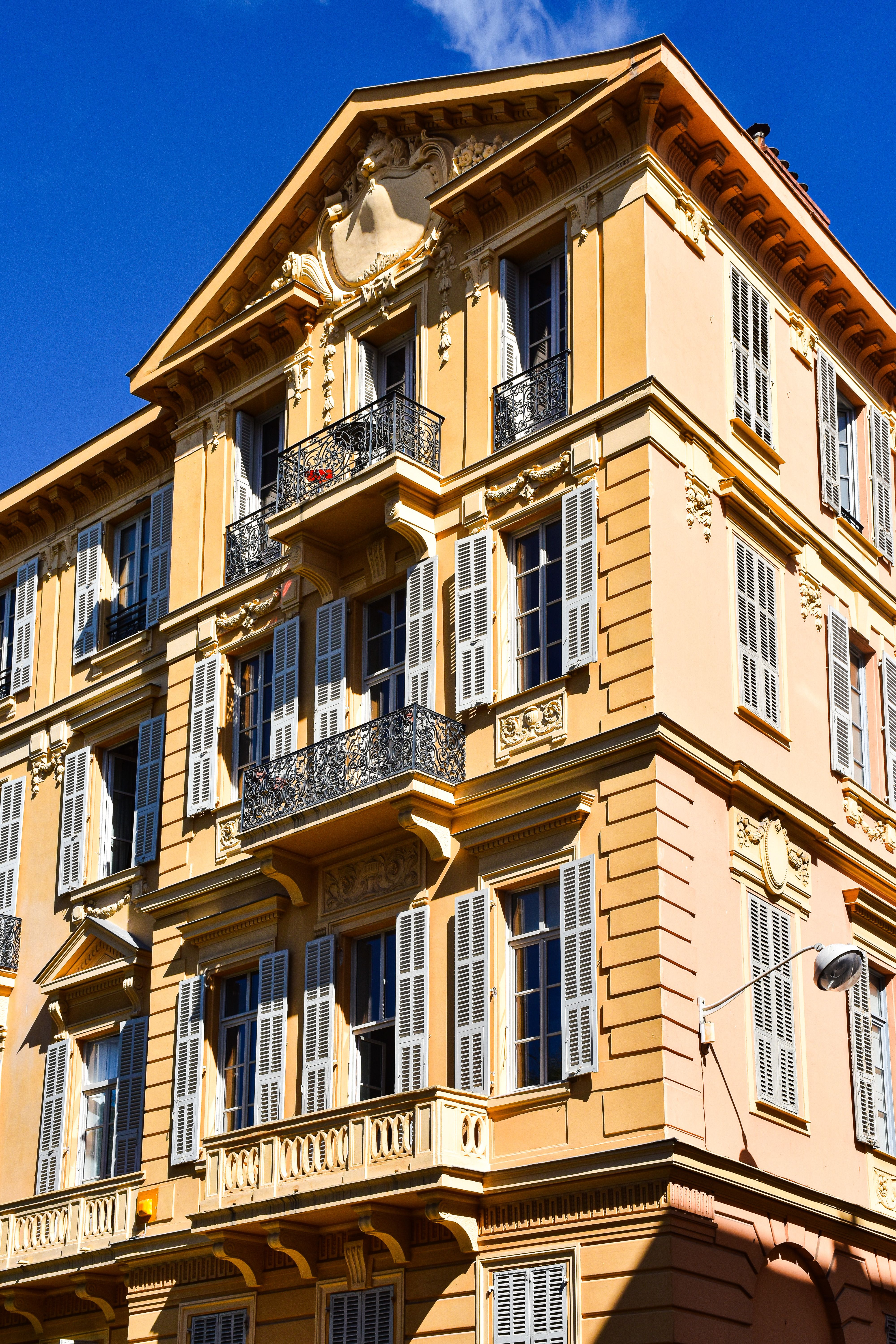 Sunlit building façade in Provence showcasing classic French architectural style.
