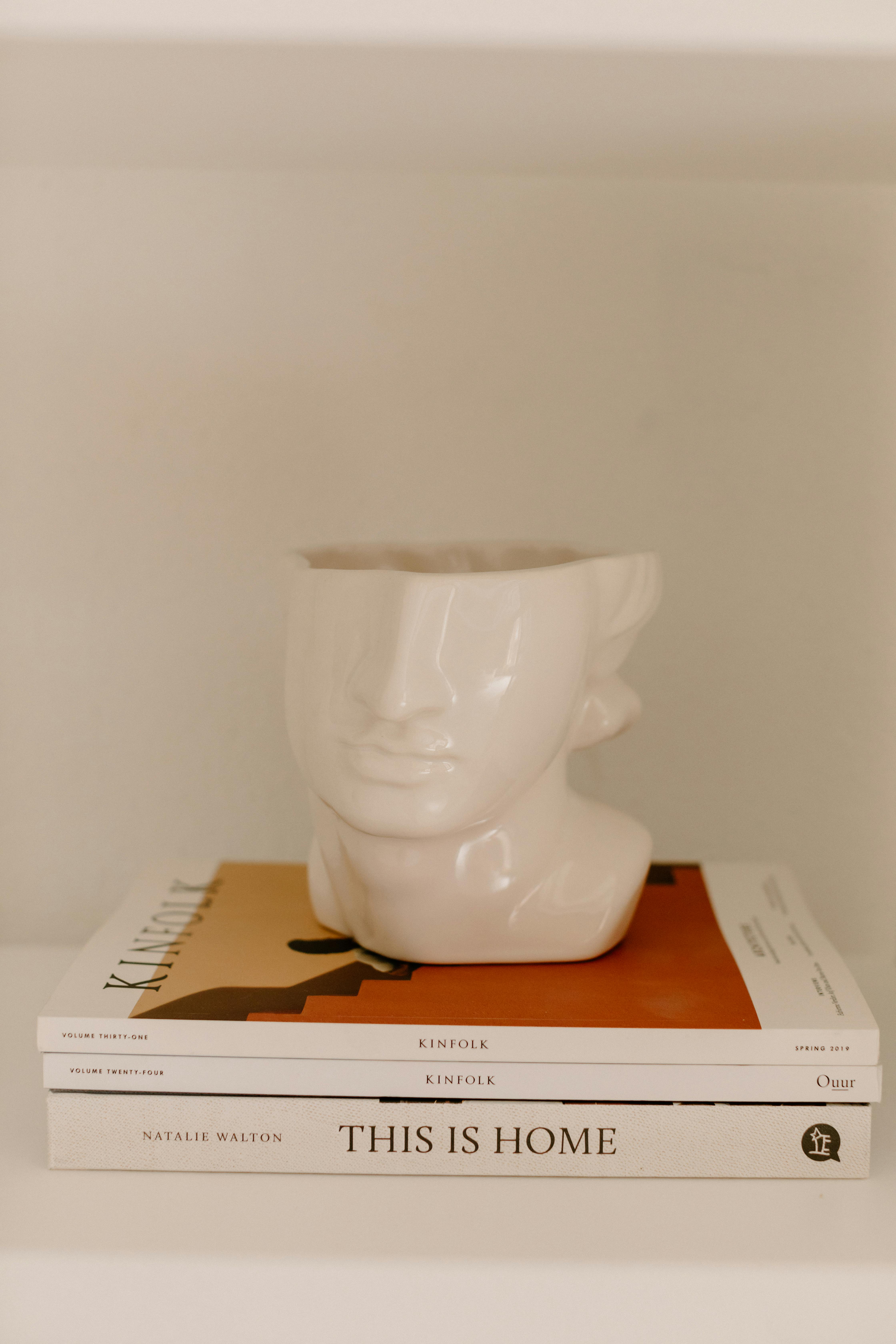 Minimalist decor featuring ceramic vase and stylish books on a shelf.