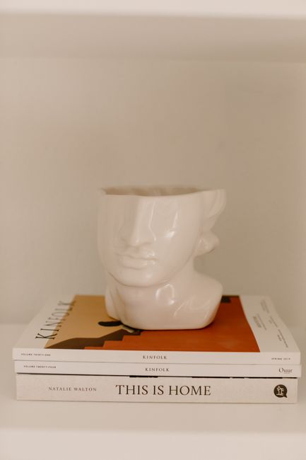 Minimalist decor featuring ceramic vase and stylish books on a shelf.