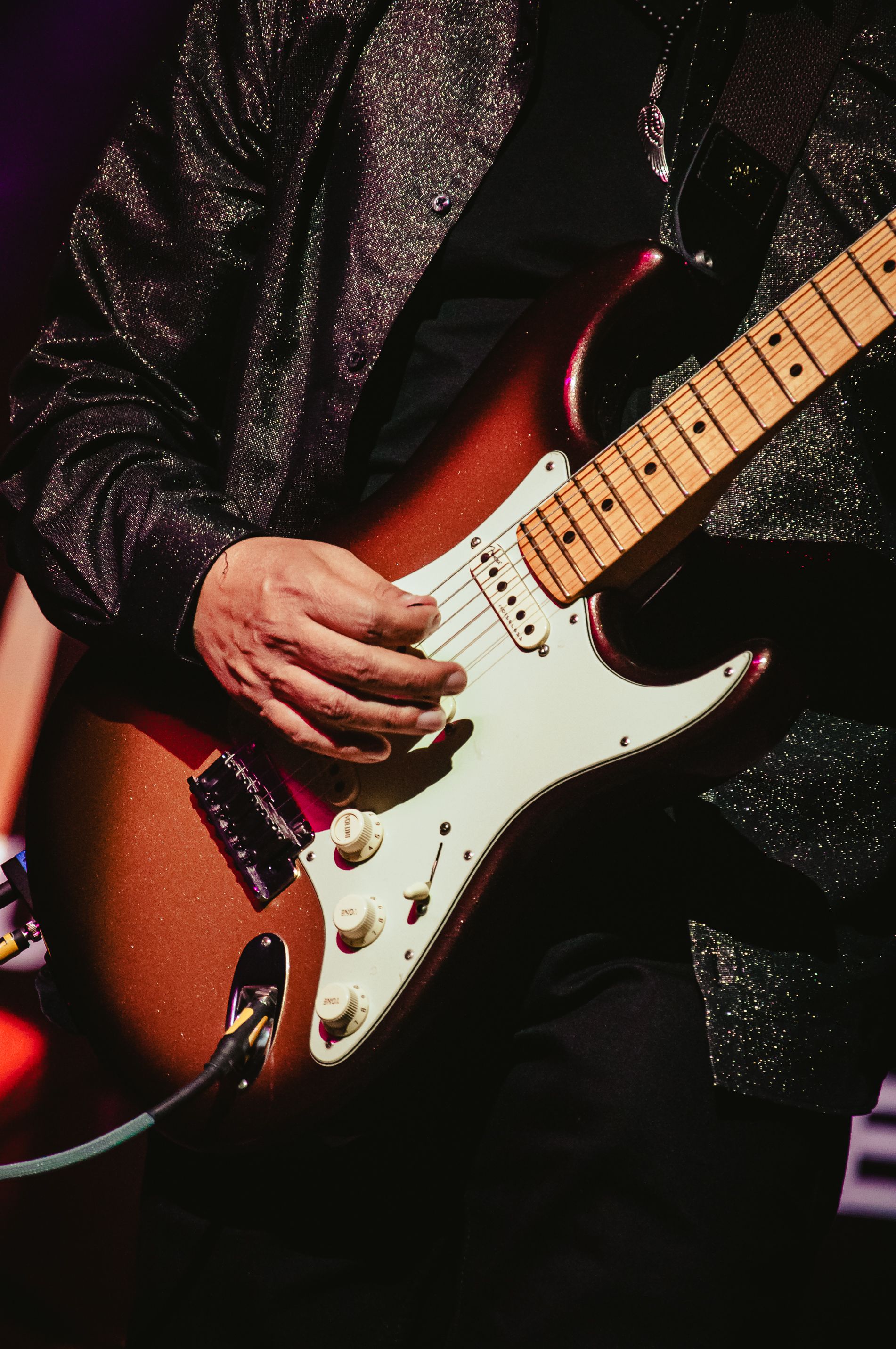 Close-up of guitarist playing an electric guitar on stage during a concert in Tlaxcala, Mexico.