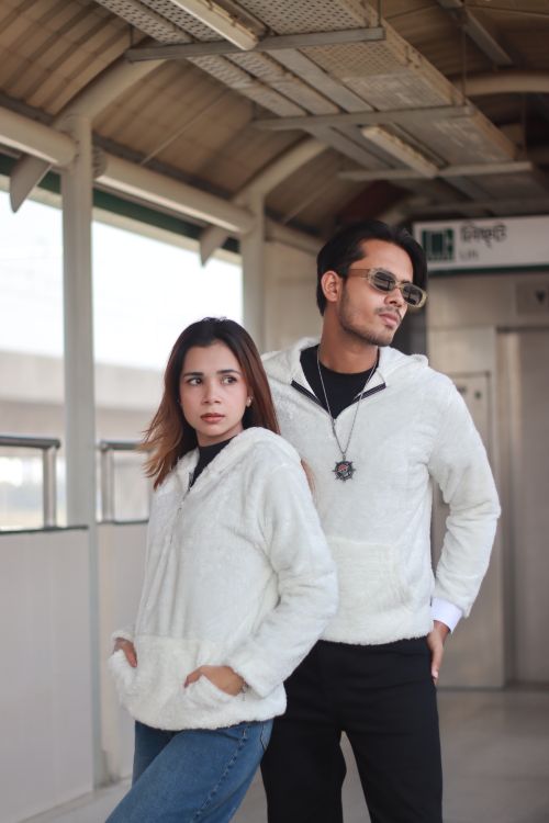 Free Modern couple wearing white jackets posing at an urban train station. Stock Photo