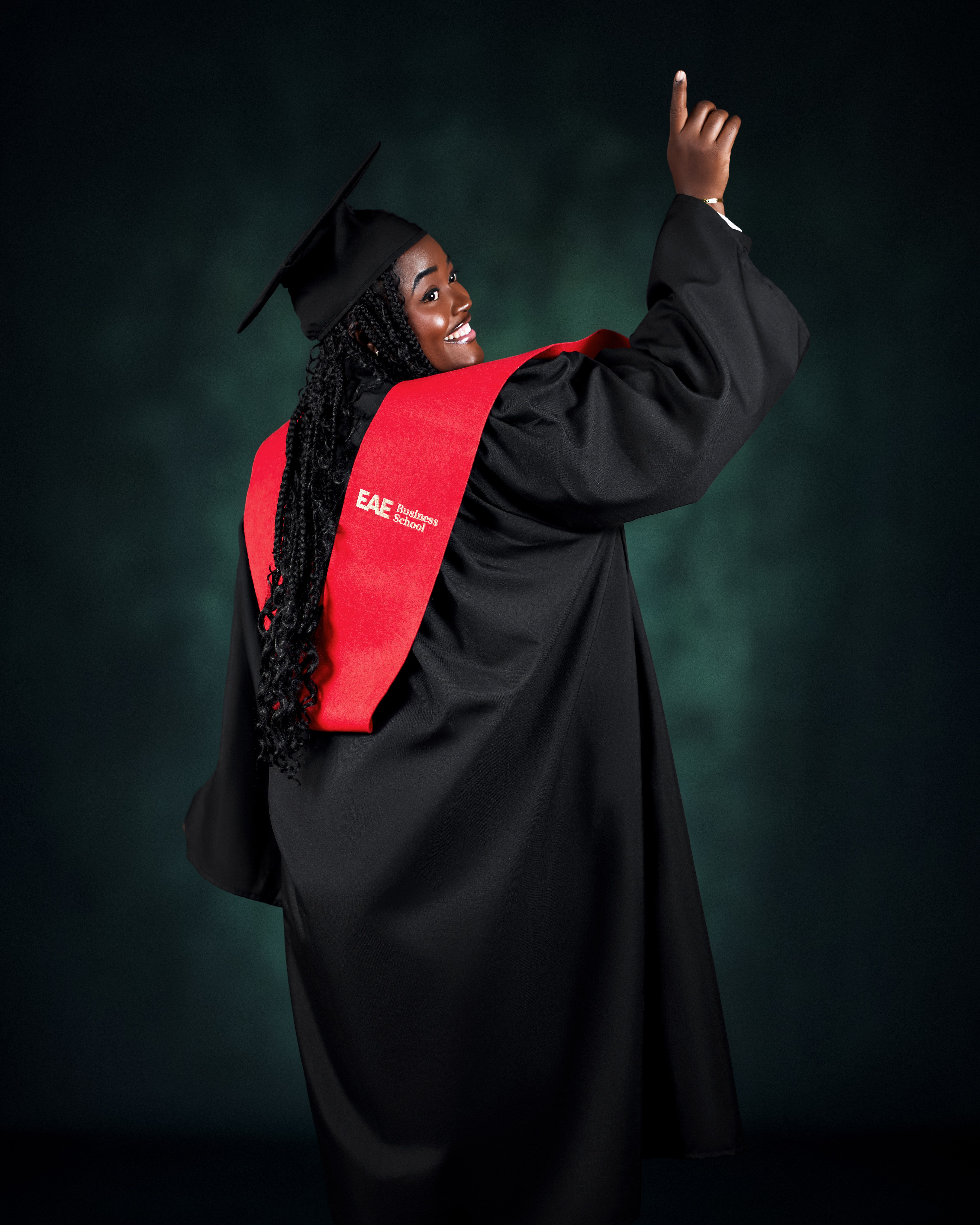 Happy graduate in black cap and gown celebrating her achievement on graduation day.