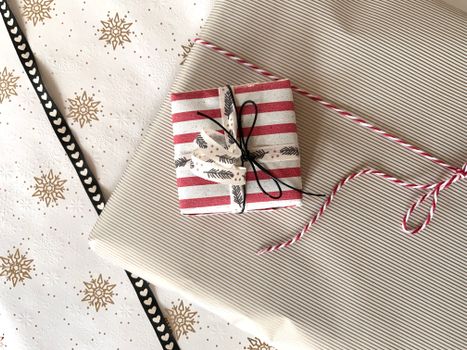 Festive holiday gifts wrapped in red striped paper and snowflake decorated background.