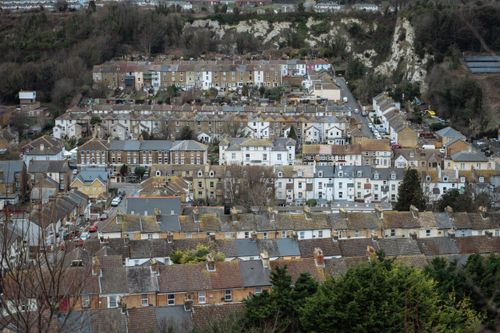 Free Aerial view of a historic British hillside neighborhood with terracotta rooftops and tightly packed homes. Stock Photo