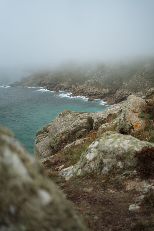 Free Foggy coastal scenery with rocky cliffs and misty ambiance, showcasing nature's raw beauty in England. Stock Photo