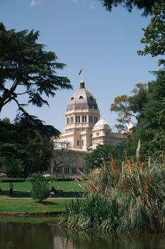 The iconic Royal Exhibition Building surrounded by lush greenery in Melbourne, Australia.